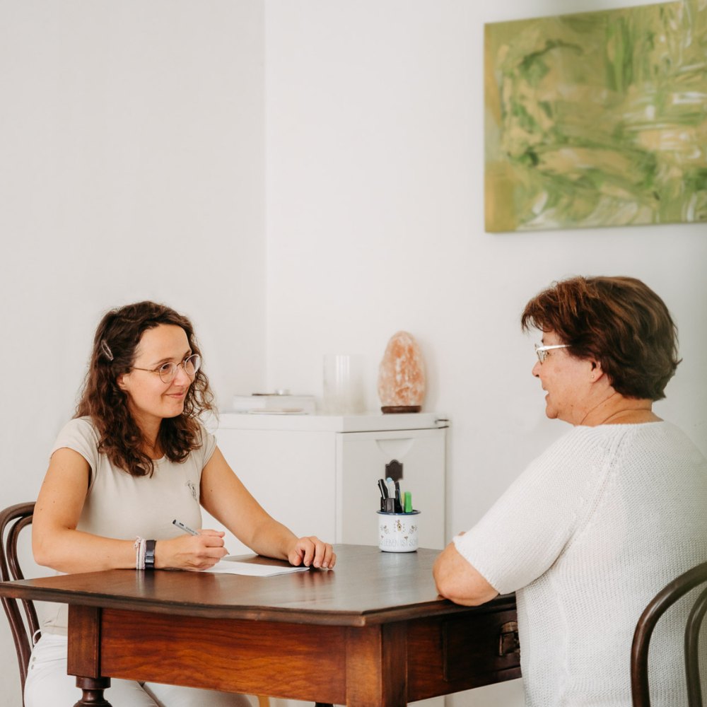 Logopädin Fankhauser beim Gespräch mit Patientin. Sie lächelt freundlich.